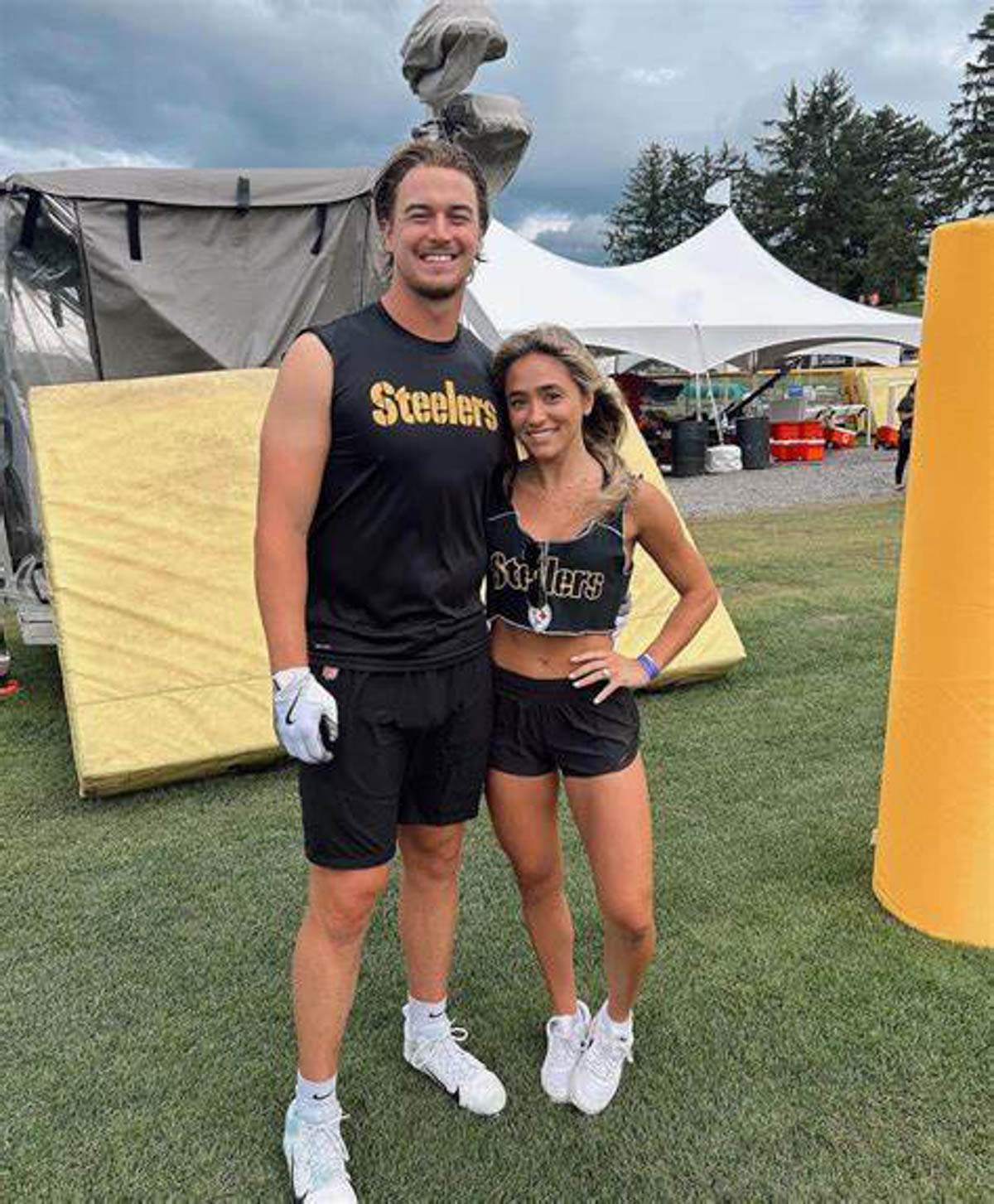 Amy Pickett and Kenny Pickett on grass in steelers gear.